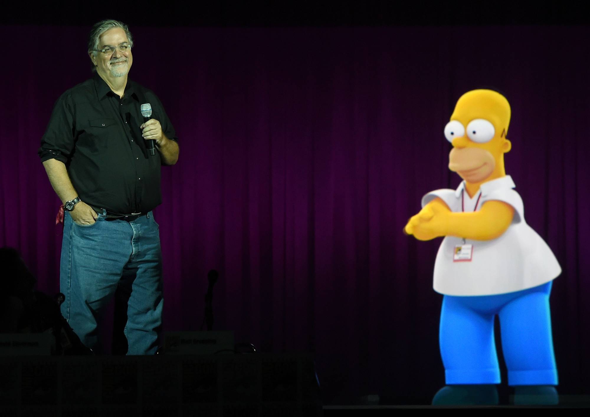 Writer/producer Matt Groening interacts with a projection of Homer Simpson