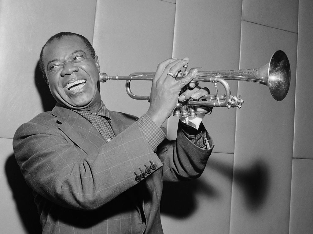 Grayscale Portrait Photo of Louis Armstrong holding his trumpet