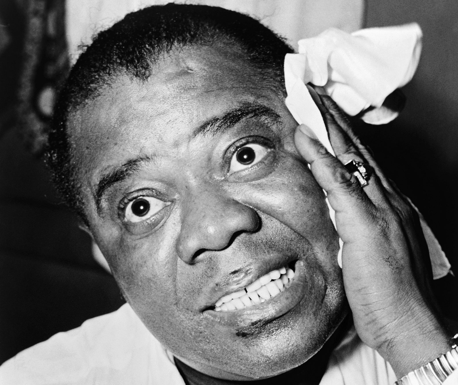 Grayscale Head and shoulders portrait of jazz musician Louis Armstrong.