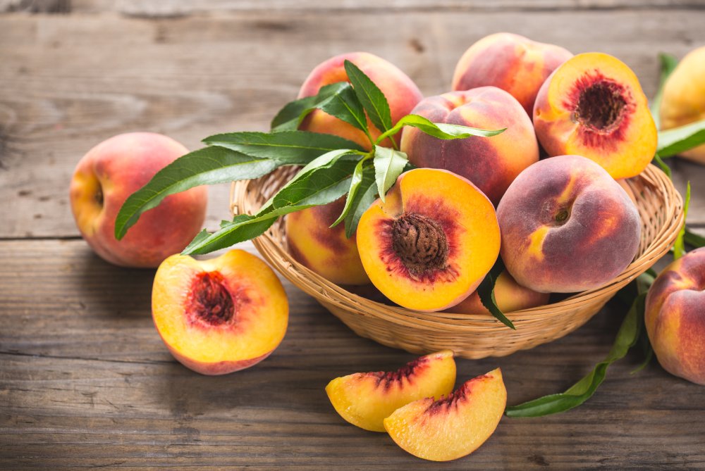 Overhead Photo of Fresh peaches in the basket placed on a wooden table