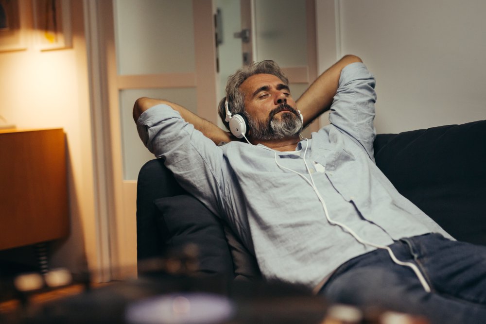 Portrait Photo of Middle aged man relaxing home and listening music