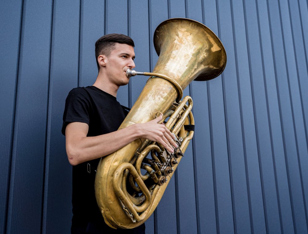 Portrait Photo of  Young street musician playing the tuba