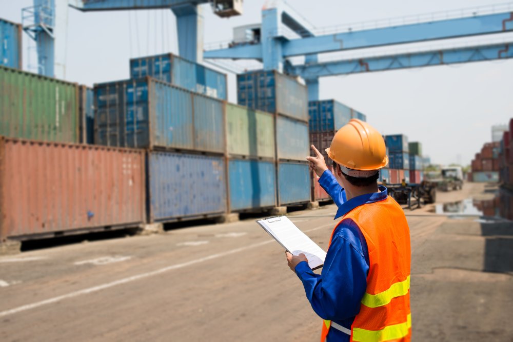 This image features a shot of a person standing against a cargo ship