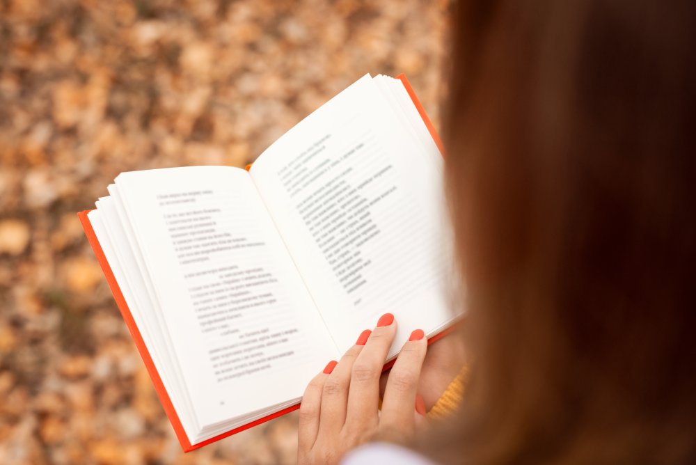 Close Up Photo of Woman reading poems in autumn park