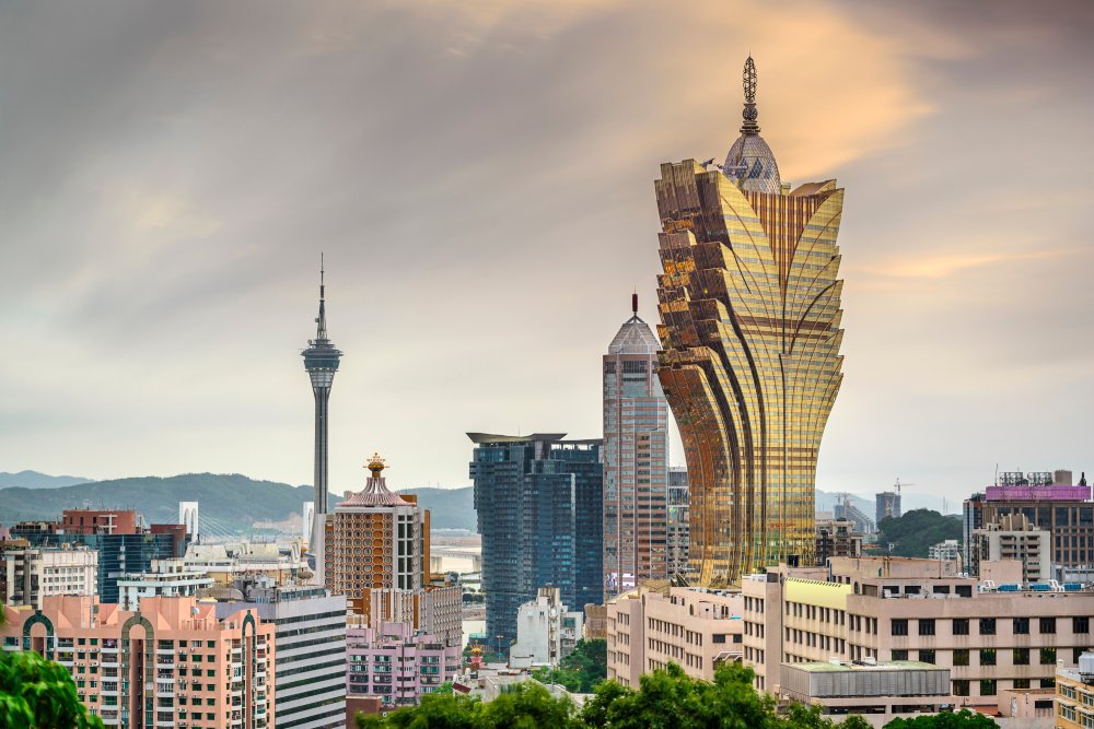 A cityscape panorama showcases Macau, China Casino Resorts against a cloudy sky