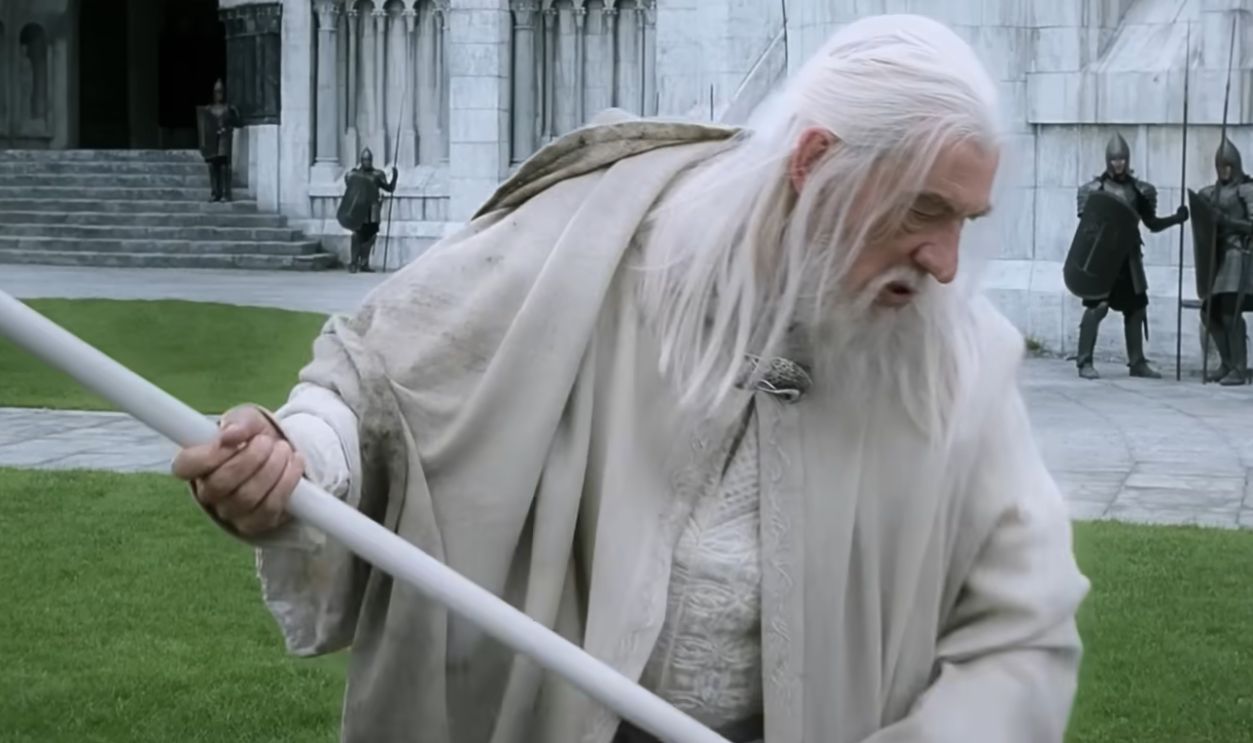 White haired man looking down