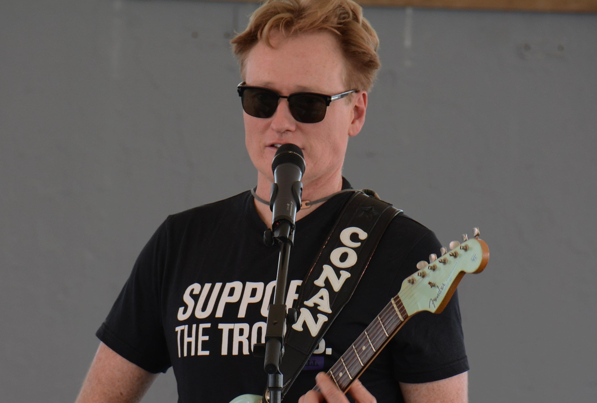 Late night talk show host and comedian, Conan O’Brien, plays his guitar