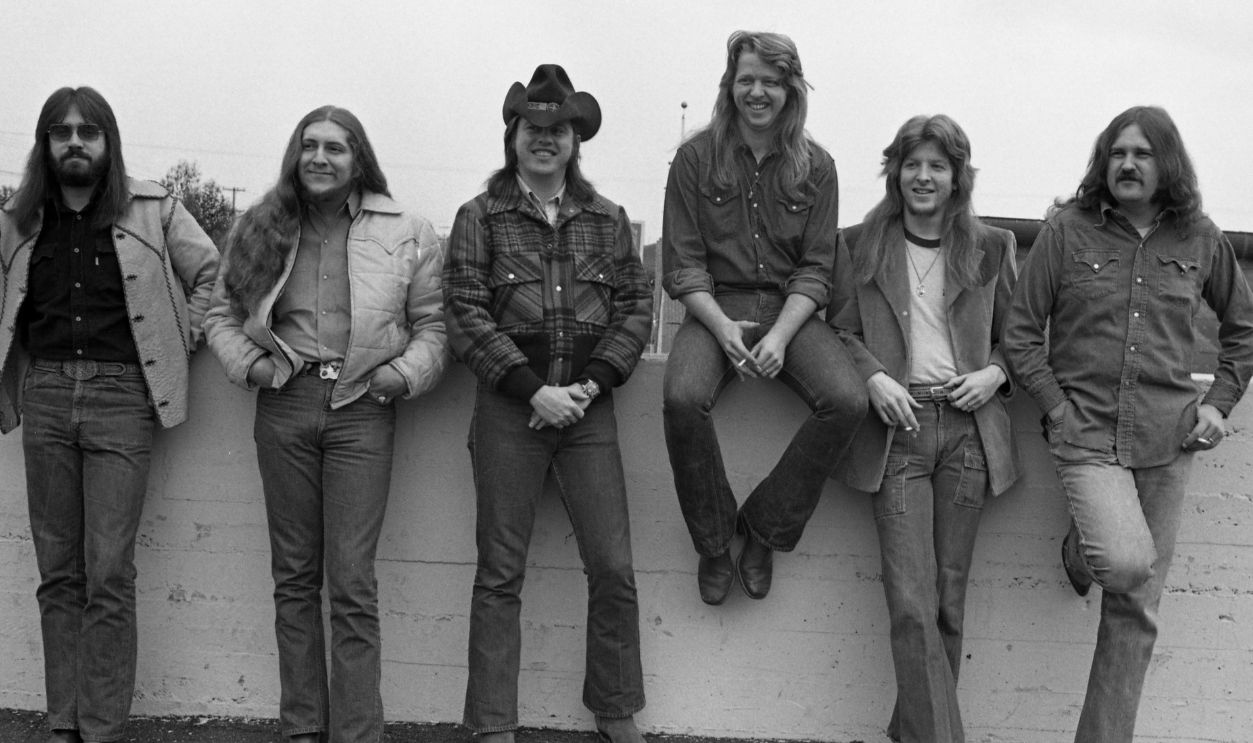 Southern, Country and Roots Rock, Marshall Tucker Band pose for photo outside concert hall backstage door 1973 in San Francisco, California.