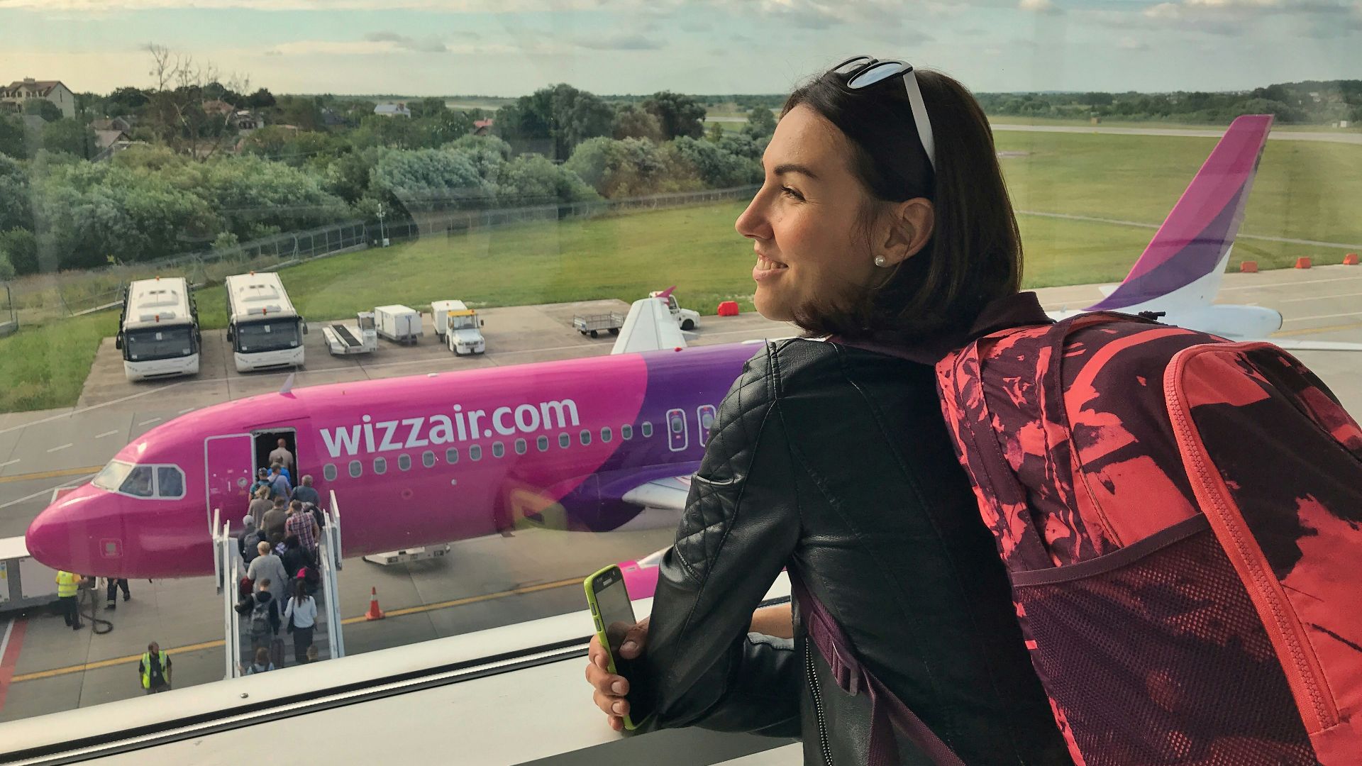 a woman looking out a window at an airplane