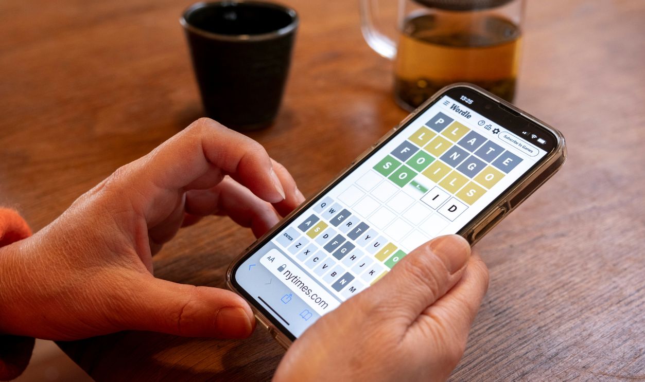 Woman plays Wordle on her smartphone at the kitchen table of her home on 26th November 2023 in Birmingham, United Kingdom. Wordle is a web-based word game played by millions of users / players worldwide often on their mobile devices. The game was created and developed by software engineer Josh Wardle, and owned by The New York Times Company since 2022. 