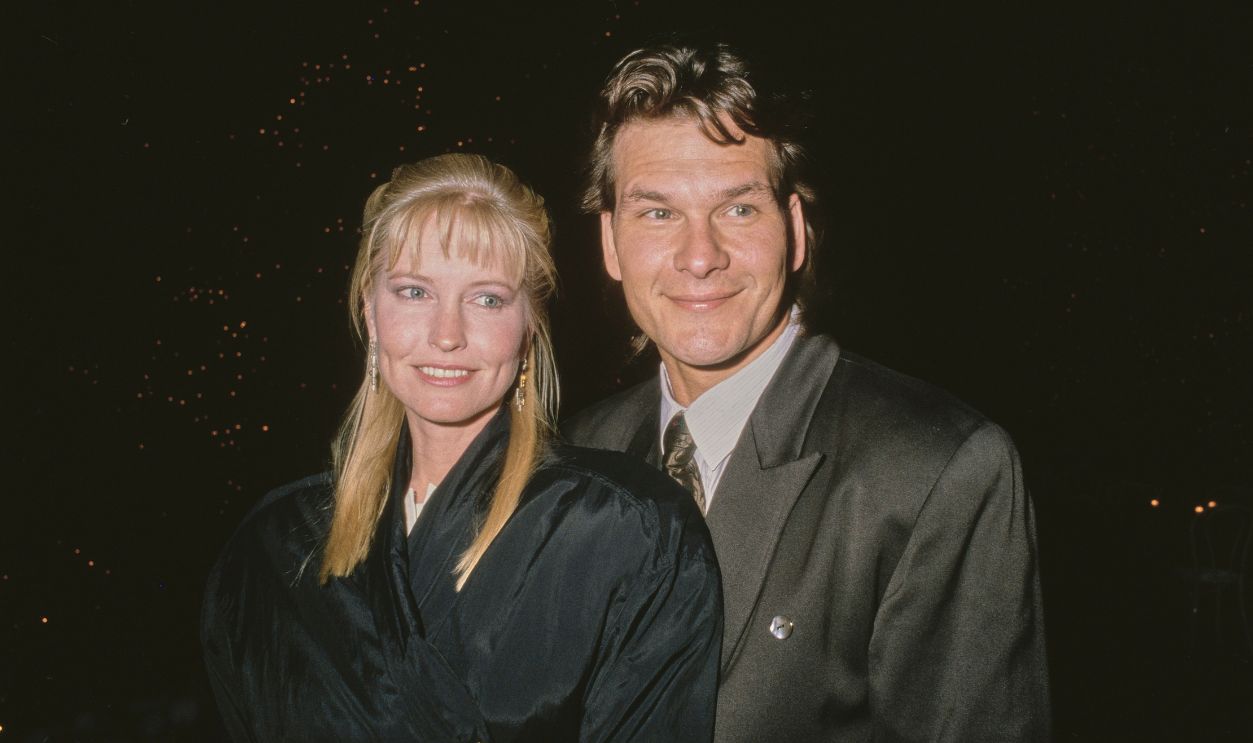 American dancer, choreographer and actress Lisa Niemi, wearing a black coat, with her husband, American actor, singer and dancer Patrick Swayze, who wears a dark grey suit jacket, attend Sandy Gallin's Christmas Party, held at Gallin's home in Beverly Hills, California, 18th December 1988.