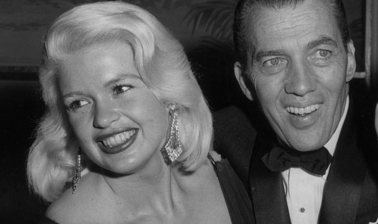 Jayne Mansfield 1957: American variety show host Ed Sullivan stands with his arms around American actor Jayne Mansfield (L) and American singer Sophie Tucker, at the Golden Globes, also known as the Hollywood Foreign Press Association Awards, Los Angeles, California. Mansfield won a Golden Globe that year for Most Promising Female Newcomer.