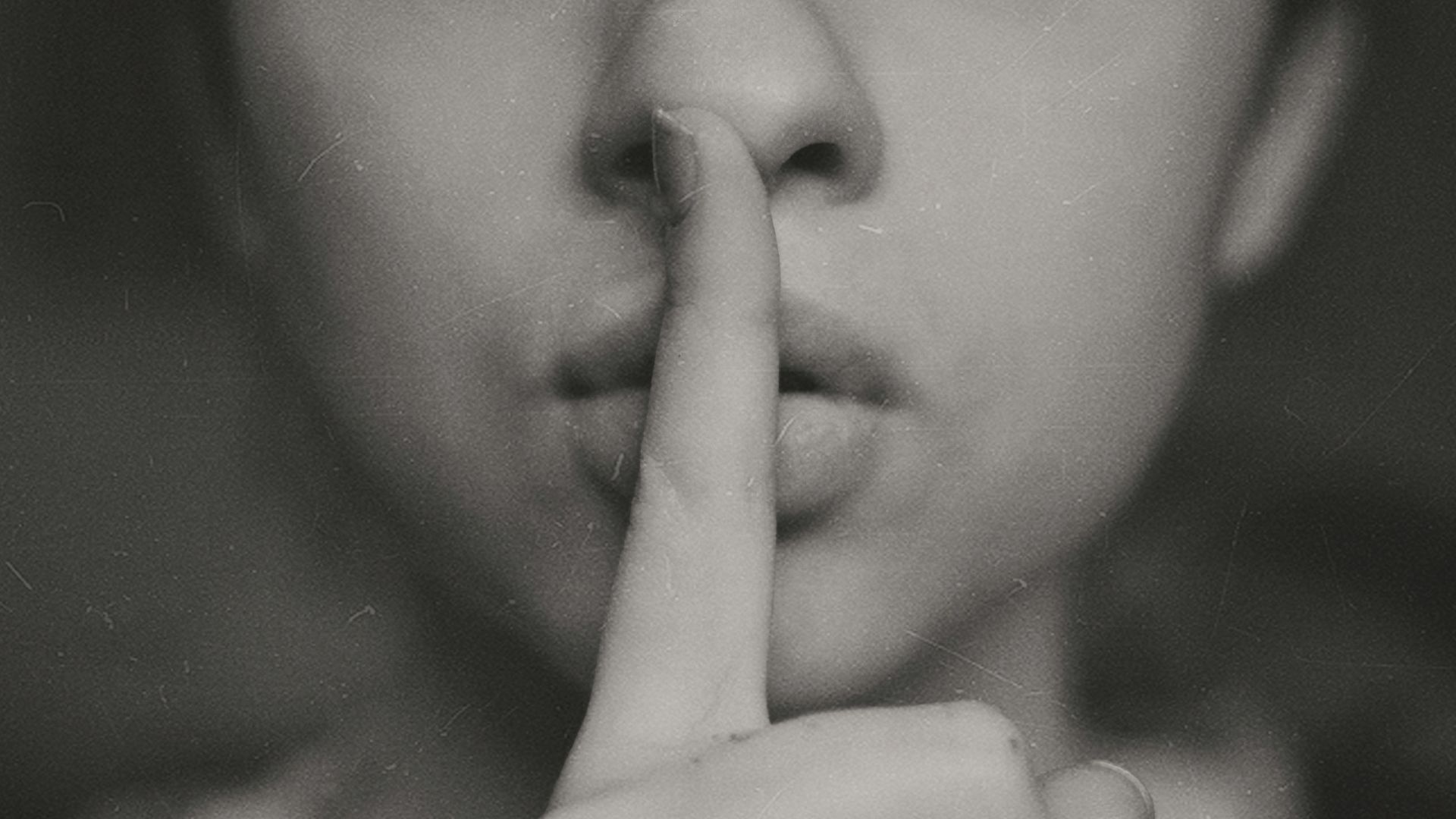 grayscale photo of woman doing silent hand sign