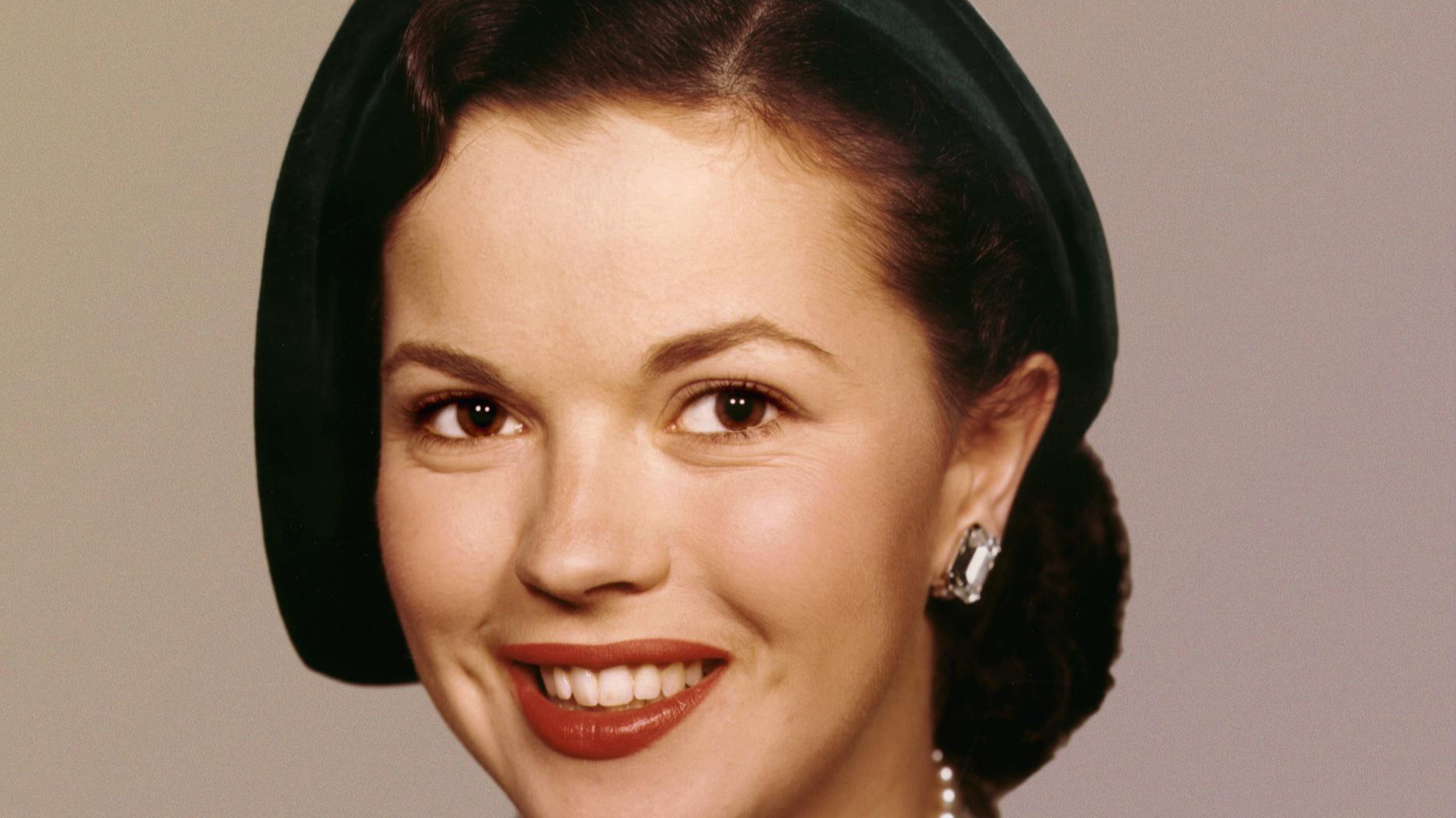 Shirley Temple in brown coat and green hat