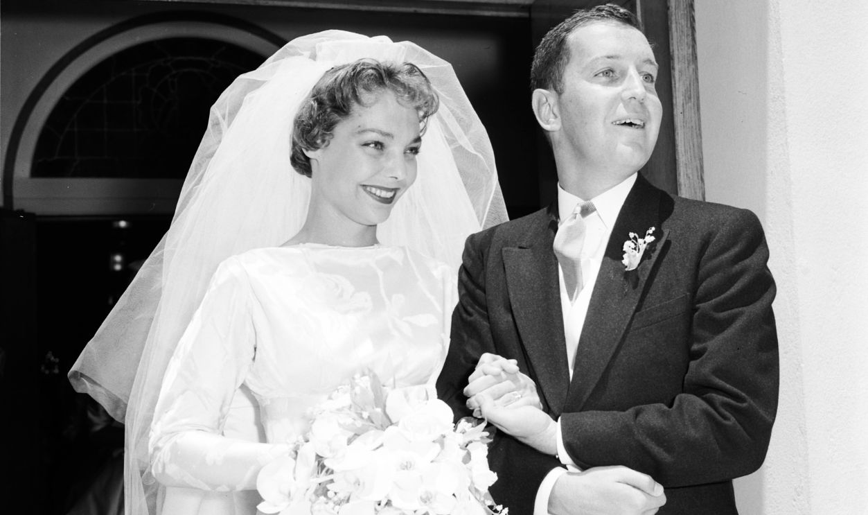 Loretta Young's daughter marries, 21 June 1958. Judith Therese Lewis (bride);Joseph Lewis Tinney Junior (groom).;Caption slip reads: 'Photographer: Miller. Date: 1958-06-21. Reporter: Farrell. Assignment: Judy Lewis marriage (Loretta Young's daughter). 219/220: Judith Therese Lewis and her bridegroom, Joseph Lewis Tinney Jr. on steps of Church of the Good Shepherd following marriage'..
