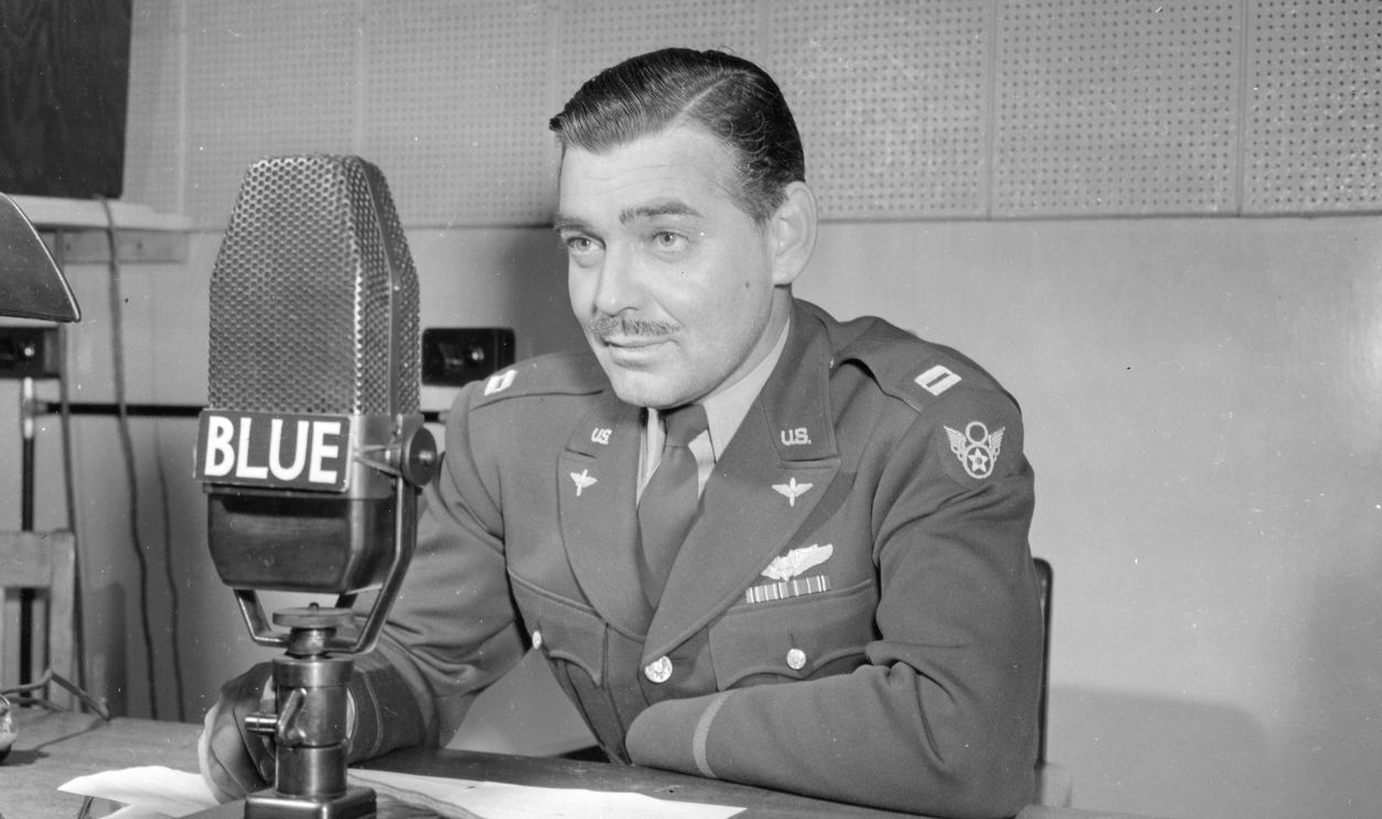 US Army Air Corps Capt Clark Gable (1901 - 1960) speaks into a microphone as he urges the purchase of War Bonds in support of the 3rd War Loan Drive program, England, 1943. 