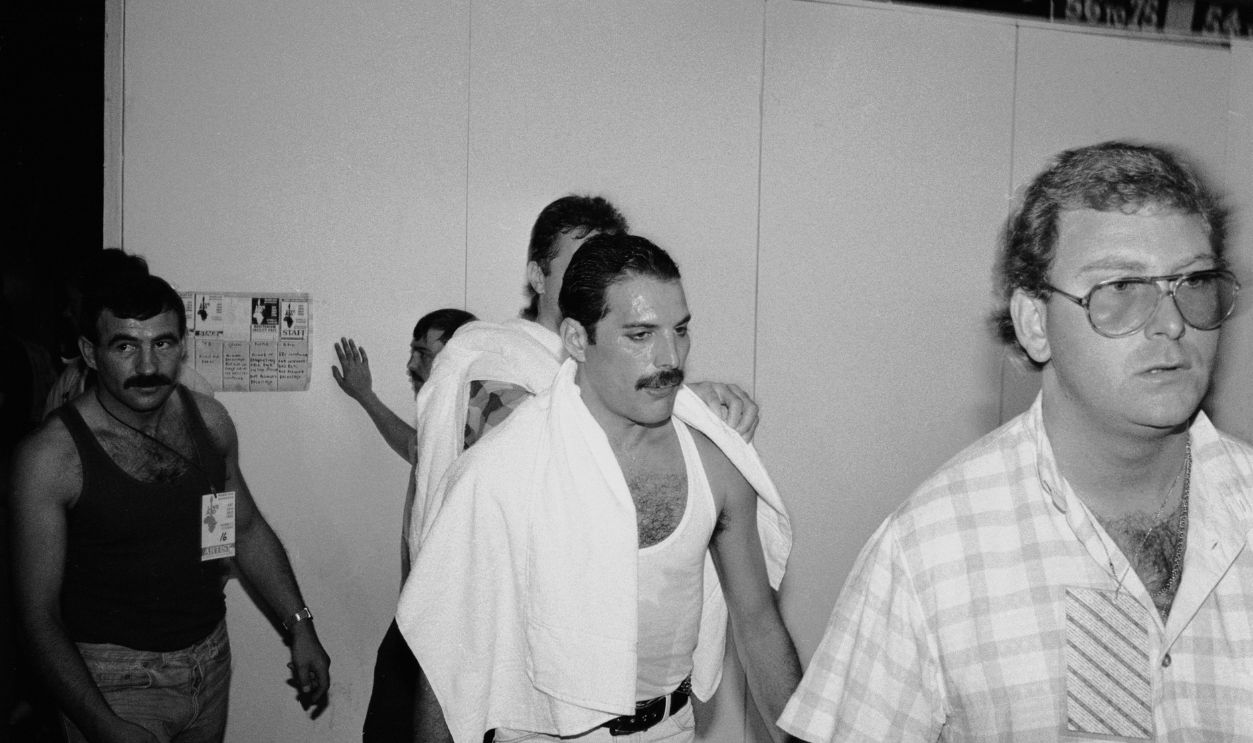 Rock star Freddie Mercury backstage at the Live Aid concert at Wembley, 13th July 1985. On the left is his boyfriend Jim Hutton.
