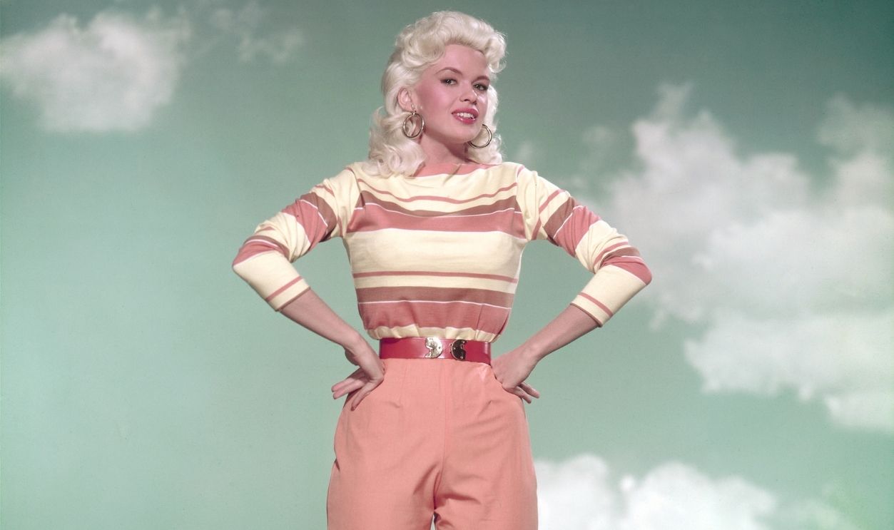 Jayne Mansfield American actress Jayne Mansfield (1933 - 1967) poses against a painted desert backdrop in peach-coloured trousers and a striped top, circa 1960. 