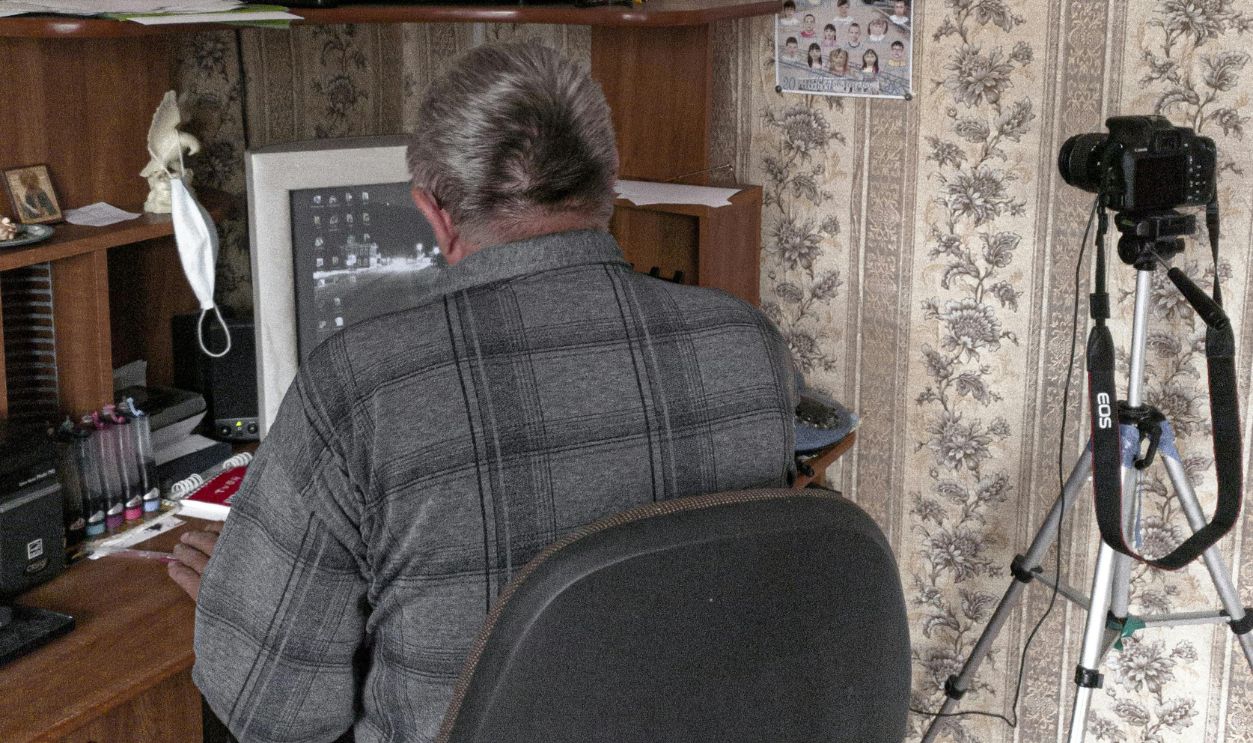Back View of Man Sitting In Front of a Computer 