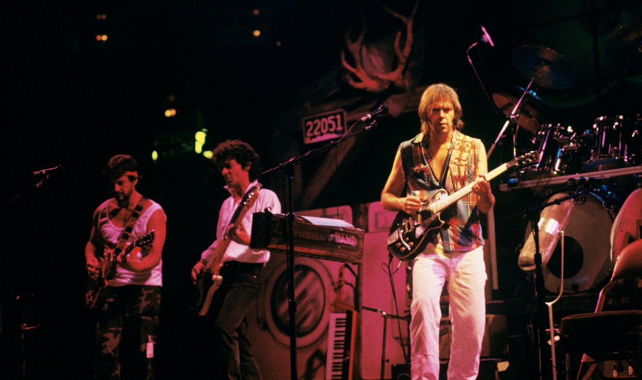 Canadian singer-songwriter Neil Young performs live on stage with Crazy Horse at the Spectrum in Philadelphia, Pennsylvania on September 17,1986. Left to right: Frank 'Poncho' Sampedro and Billy Talbot from Crazy Horse, Neil Young.