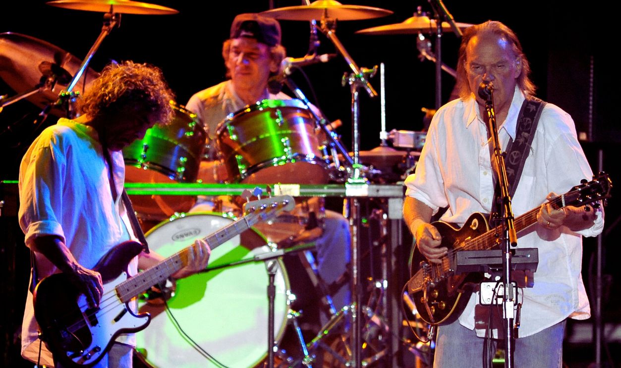 (L - R) Billy Talbot, Ralph Molina, and Neil Young of Neil Young and Crazy Horse perform in support of the bands' Americana release at the Lake Tahoe Outdoor Arena at Harveys on August 9, 2012 in Stateline, Nevada.