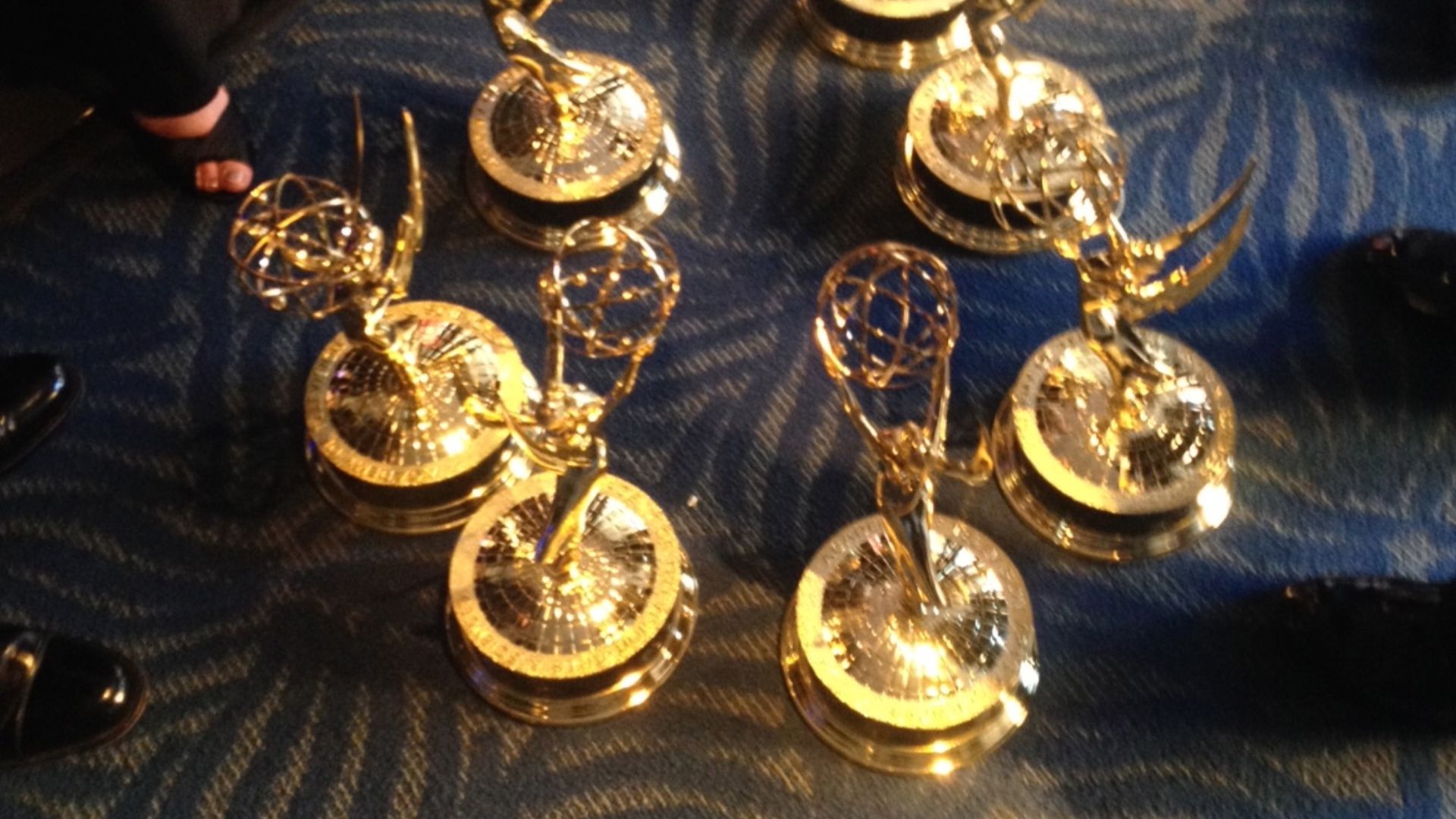 File:A bunch of Emmy Awards sitting on the ground while winners congregate and chat with each other.jpg