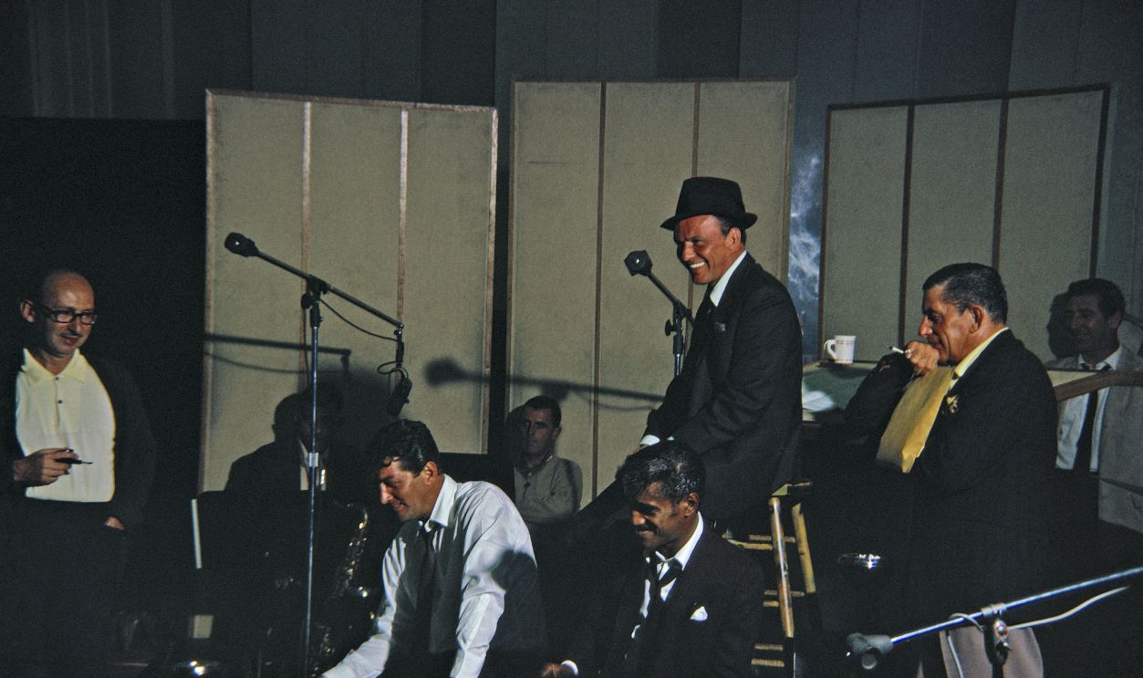 Rat Pack Recording Singers Dean Martin (seated in white shirt), Sammy Davis, Jr. (seated next to Dean Martin) and Frank Sinatra (in hat) record in the studio in October 1962 in Los Angeles, California. 