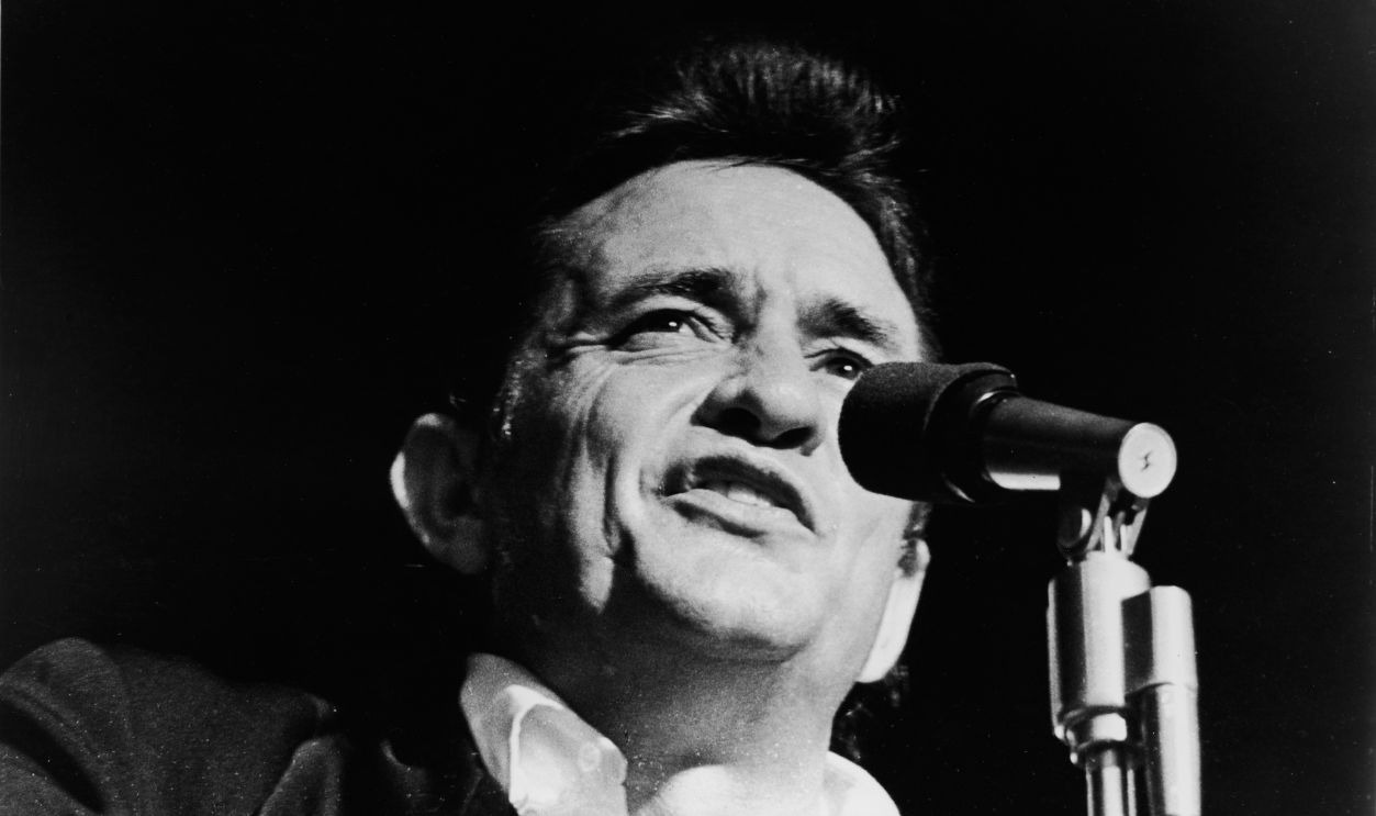 Headshot of American country singer Johnny Cash (1932 - 2003) singing on stage in a still from the film, 'Johnny Cash - The Man, His World, His Music,' directed by Robert Elfstrom, 1969.