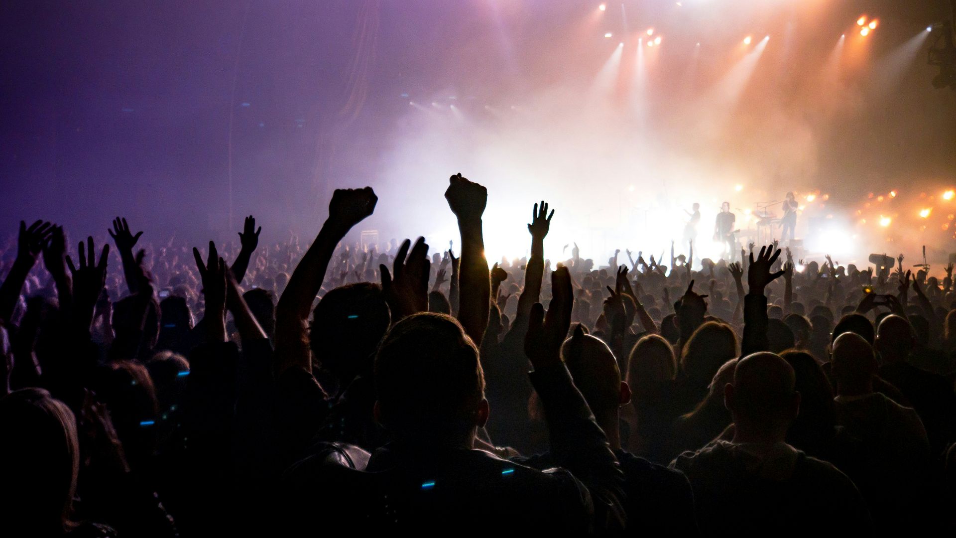 crowd facing lighted stage