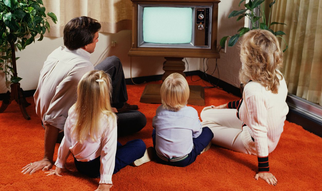 Family on floor watching television Family on floor watching television