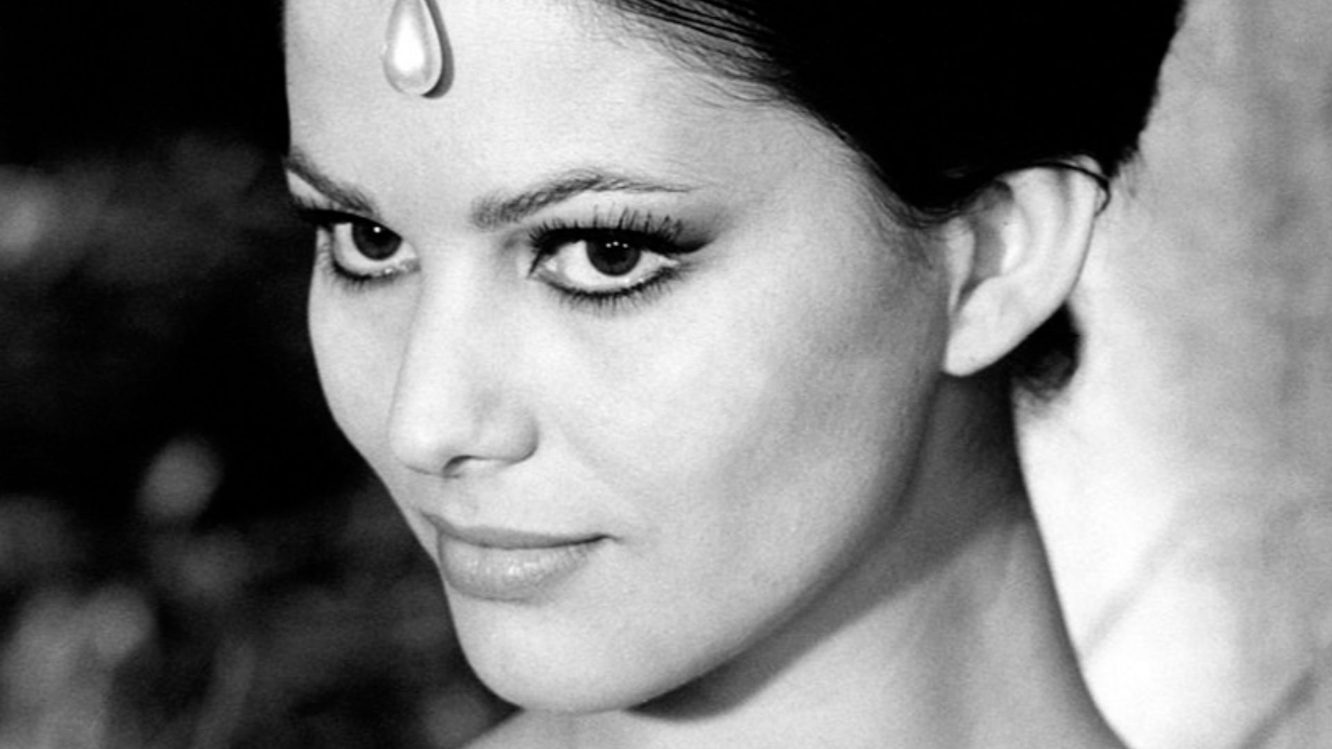 Close-up of Italian actress Claudia Cardinale and her hairstyle, embellished with a garish jewel, in occasion of the filimg of The Pink Panther by Blake Edwards, in which she plays the role of the oriental princess Dahla. Rome (Italy), February 1963.