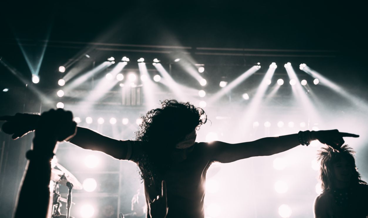 Energetic rock band performance with striking stage lights and silhouettes