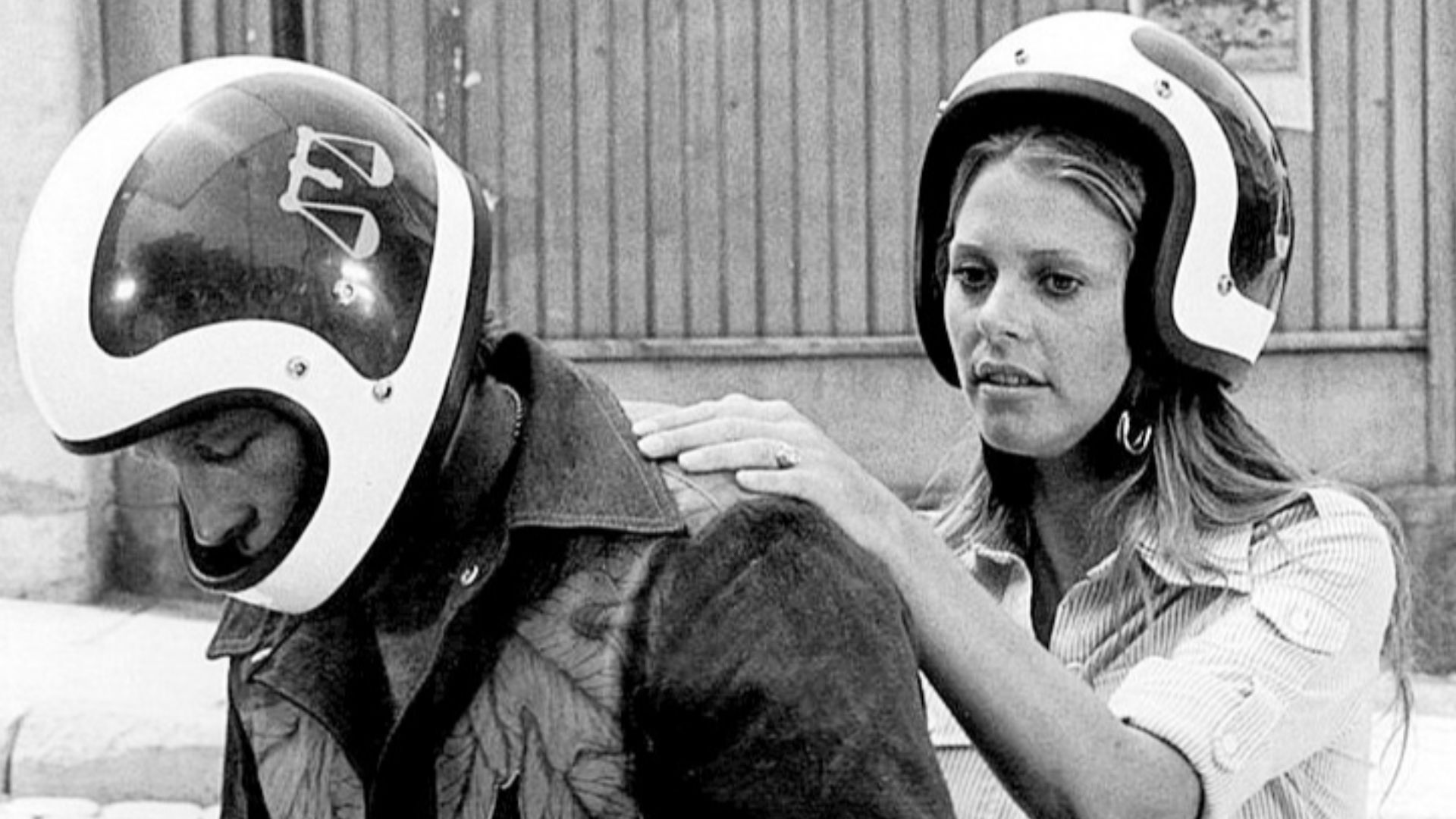 Photo of Lindsay Wagner as Jamie Sommers and guest star Evel Knievel from the television program The Bionic Woman. She asks a passing motorcyclist (Knievel) to take her from West Berlin into East Germany.