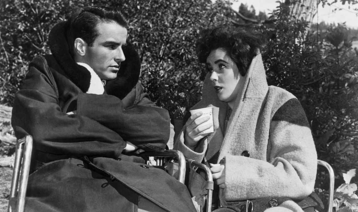 1951: Montgomery Clift (1920-1966) and Elizabeth Taylor share a relaxed moment on the set of the melodrama 'A Place In The Sun', directed by George Stevens for Paramount Pictures.