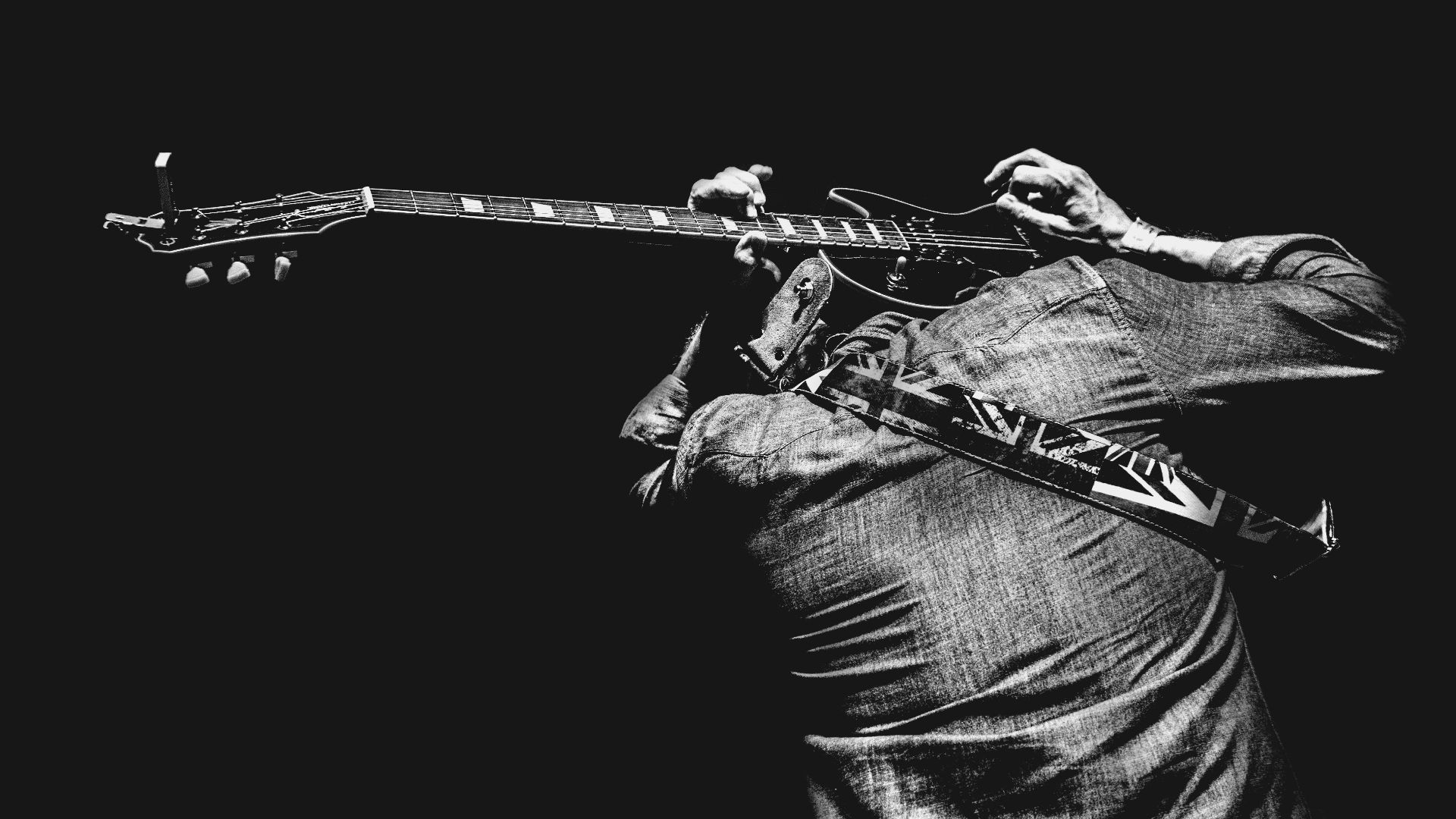 man playing guitar on his back
