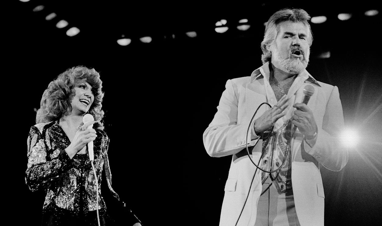 Getty Images - 1268715193 - American Country musicians Dottie West (1932 - 1991) and Kenny Rogers (1938 - 2020) perform together onstage at Nassau Coliseum, Uniondale, New York, September 26, 1980.