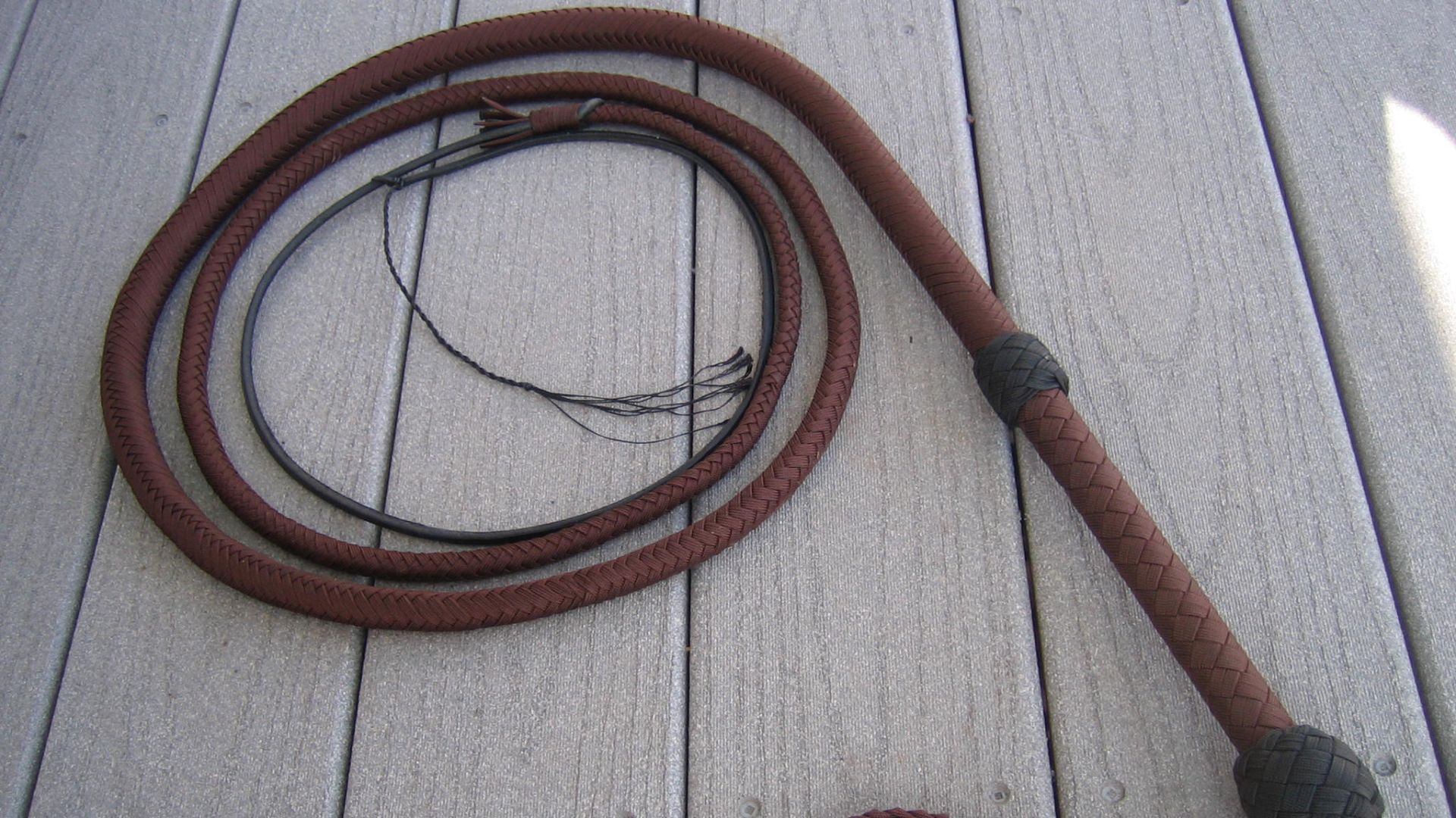 A bullwhip constructed of nylon paracord with the inner strands removed. By removing the inner strands, the paracord acts more as lace, allowing it to lay flat and to plait (braid) bullwhips such as this one pictured. This whip is constructed with a 16 pl