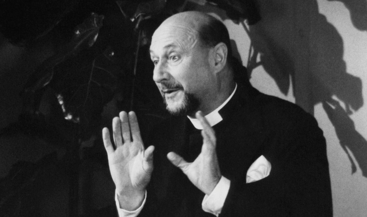 Donald Pleasence speaking with his hands raised in a scene from the film 'Oh, God!', 1977