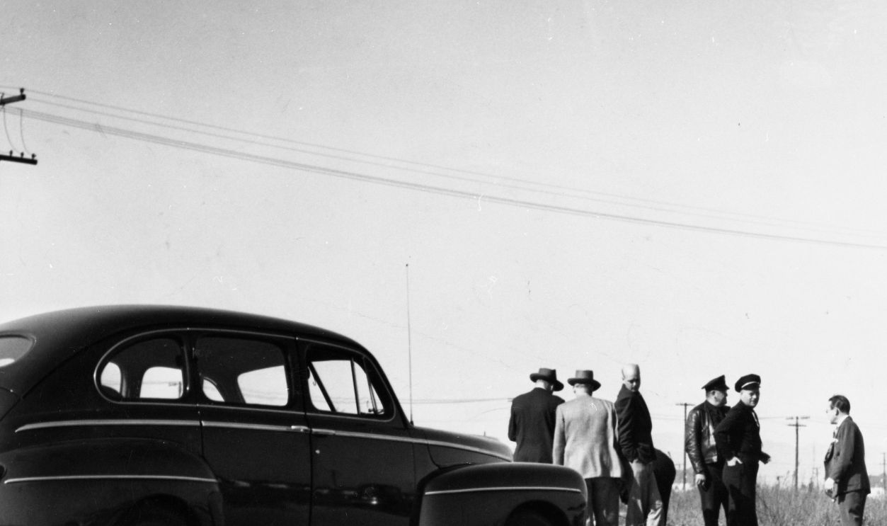 A photo of the crime scene of Elizabeth Short, also known as the Black Dahlia, showing two officers and the victims body, taken in January of 1947