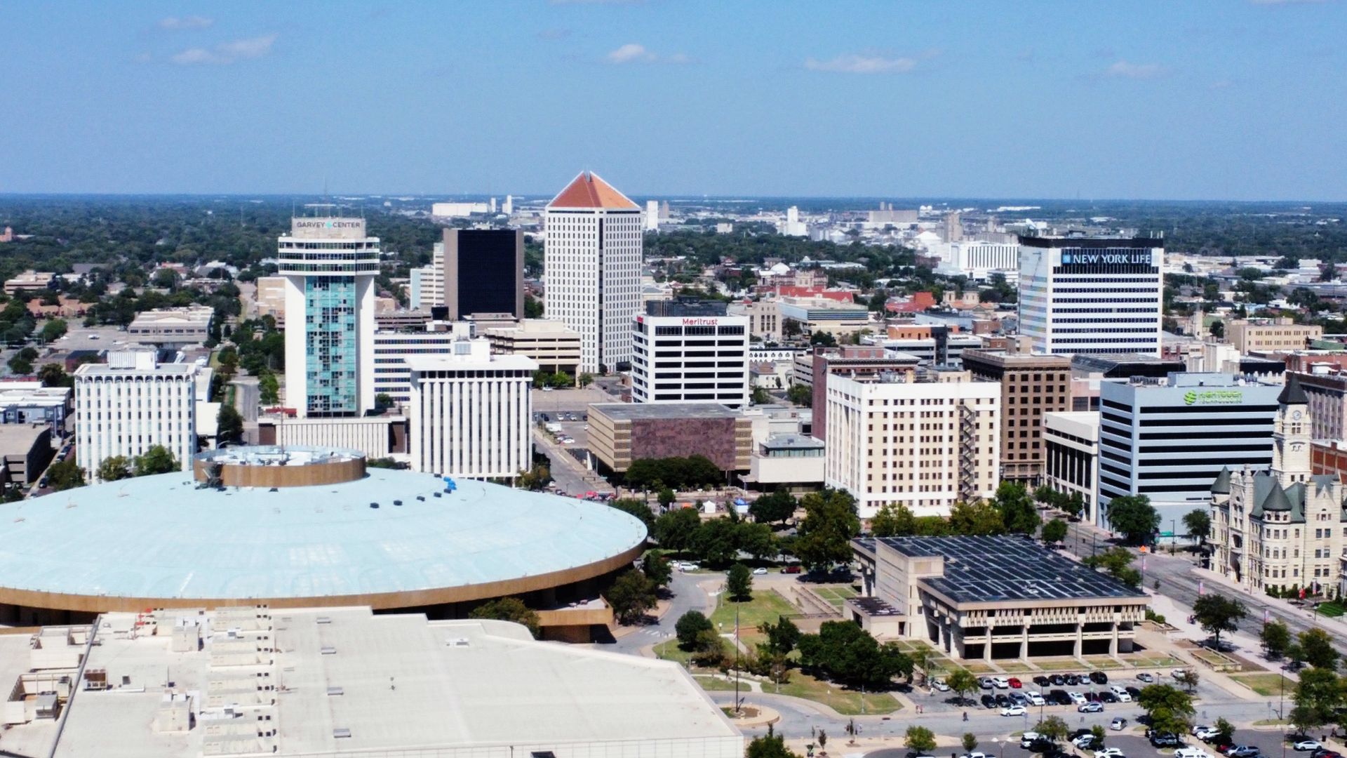 Aerial shot of Downtown Wichita skyline. Century II in foreground, Epic Center focus of shot, historic Sedgwick County Courthouse on right. Grain elevators seen in background. Looking north. 2023