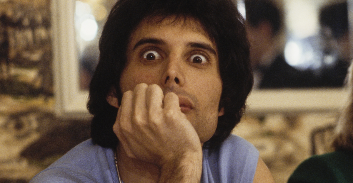 Freddie Mercury, wearing a sleeveless blue t-shirt