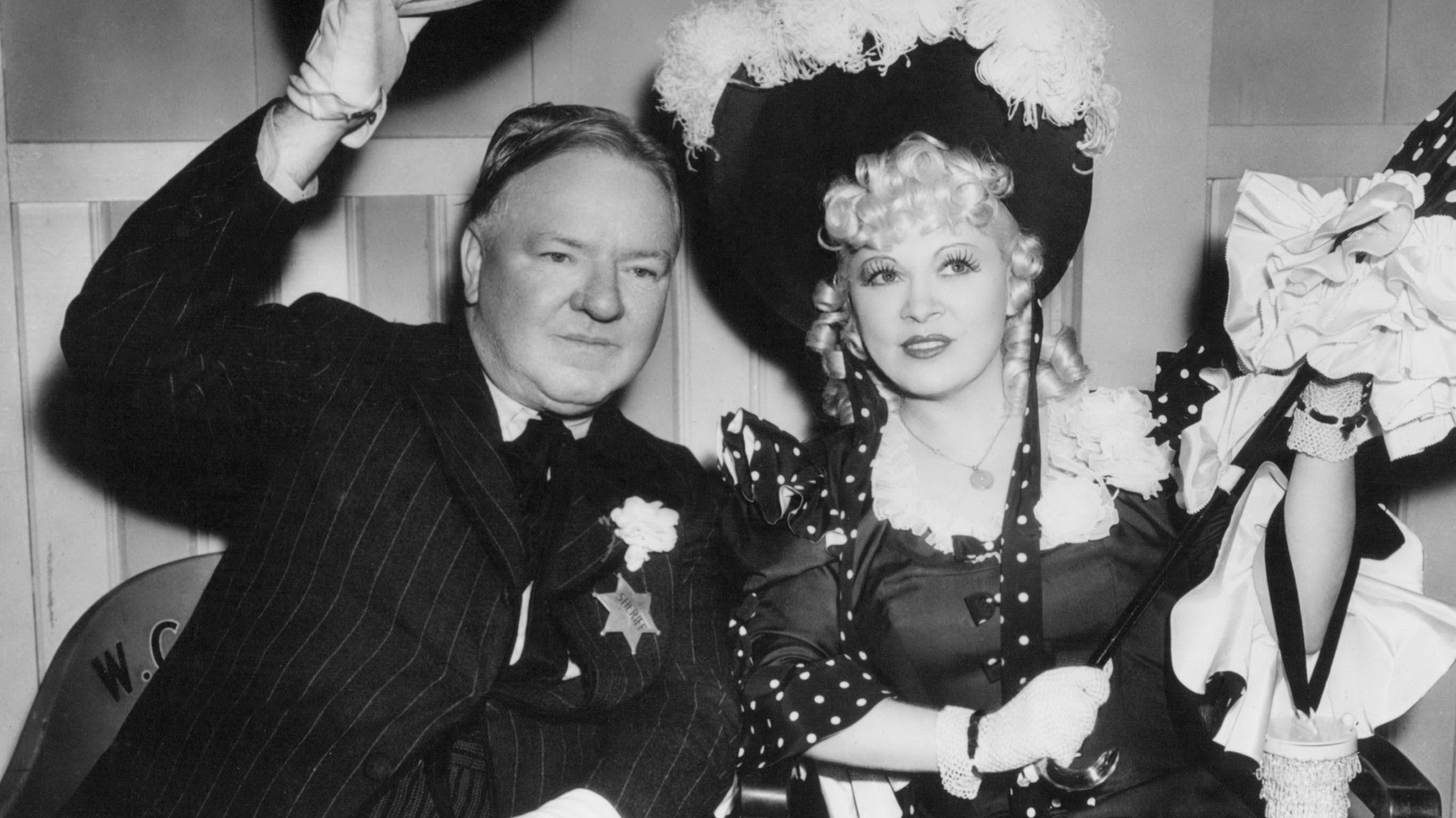 W.C. Fields (1880 - 1946), as Cuthbert J. Twillie, and Mae West (1893 - 1980) as Flower Belle Lee on the set of 'My Little Chickadee', directed by Edward F. Cline, 1940.
