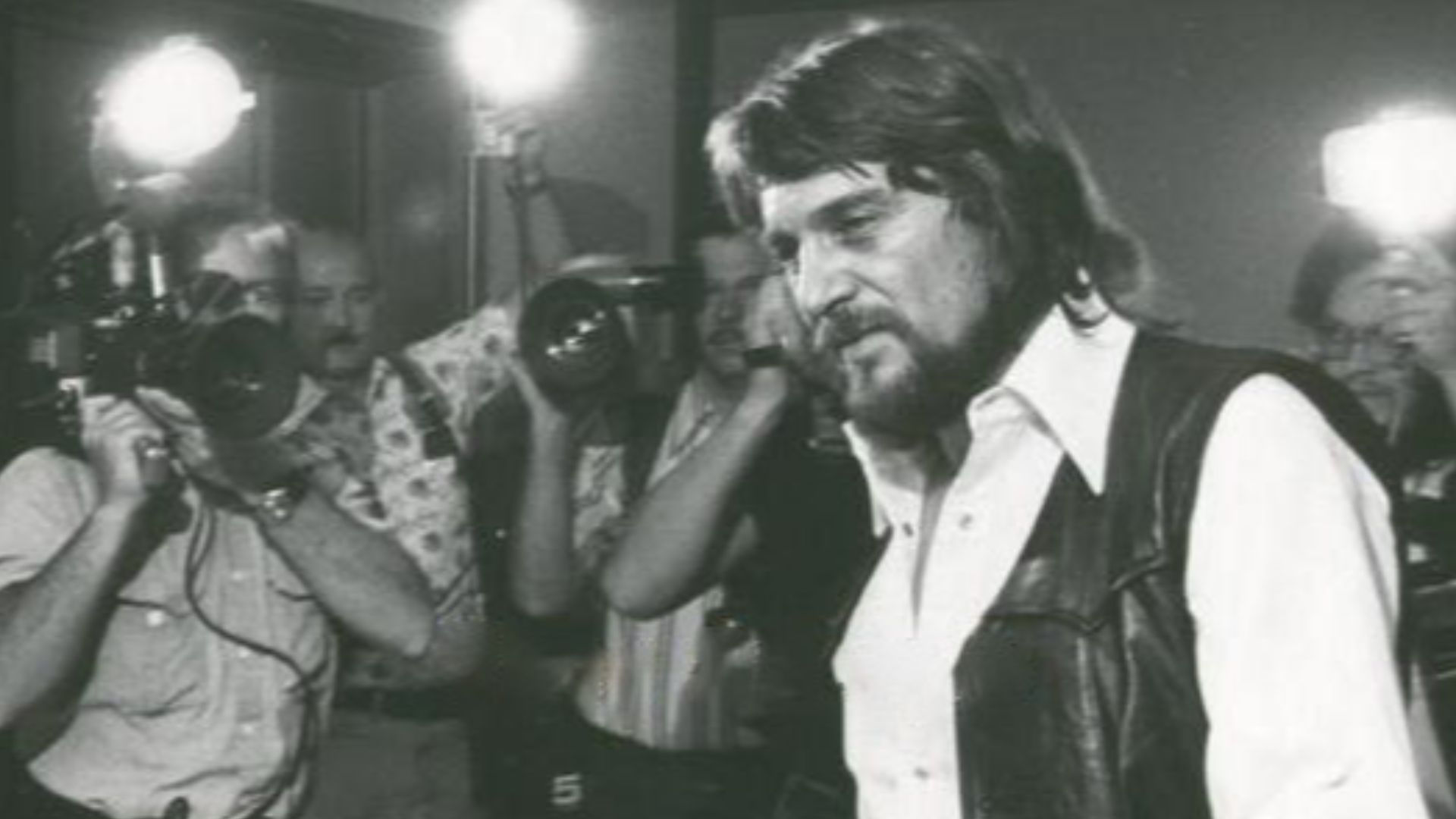 AP Wirephoto of Waylon Jennings entering a Nashville federal courthouse as he is swarmed by reporters and media on August 31, 1977.