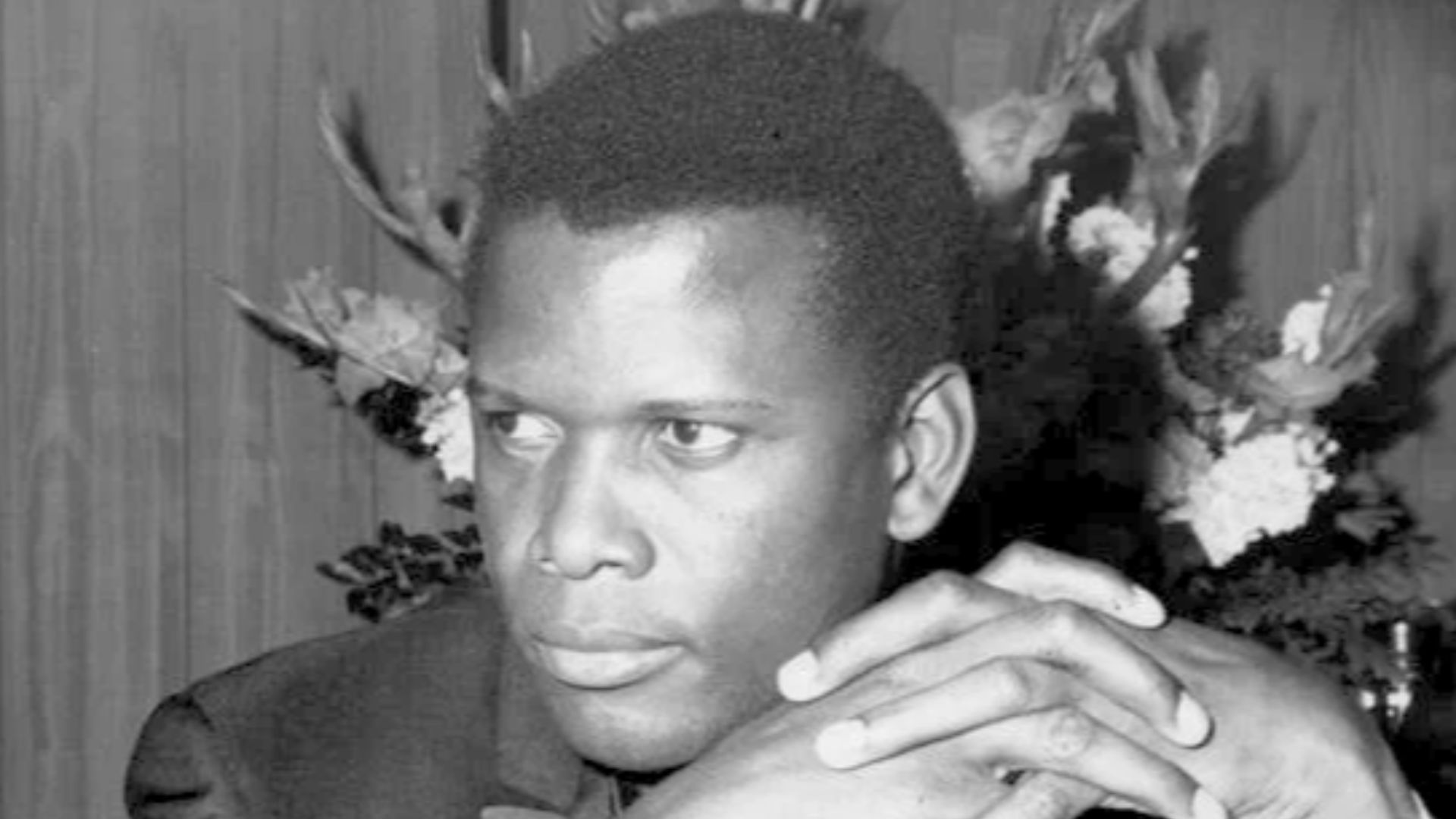 Sidney Poitier sitting during a Friars Club event in May 1964