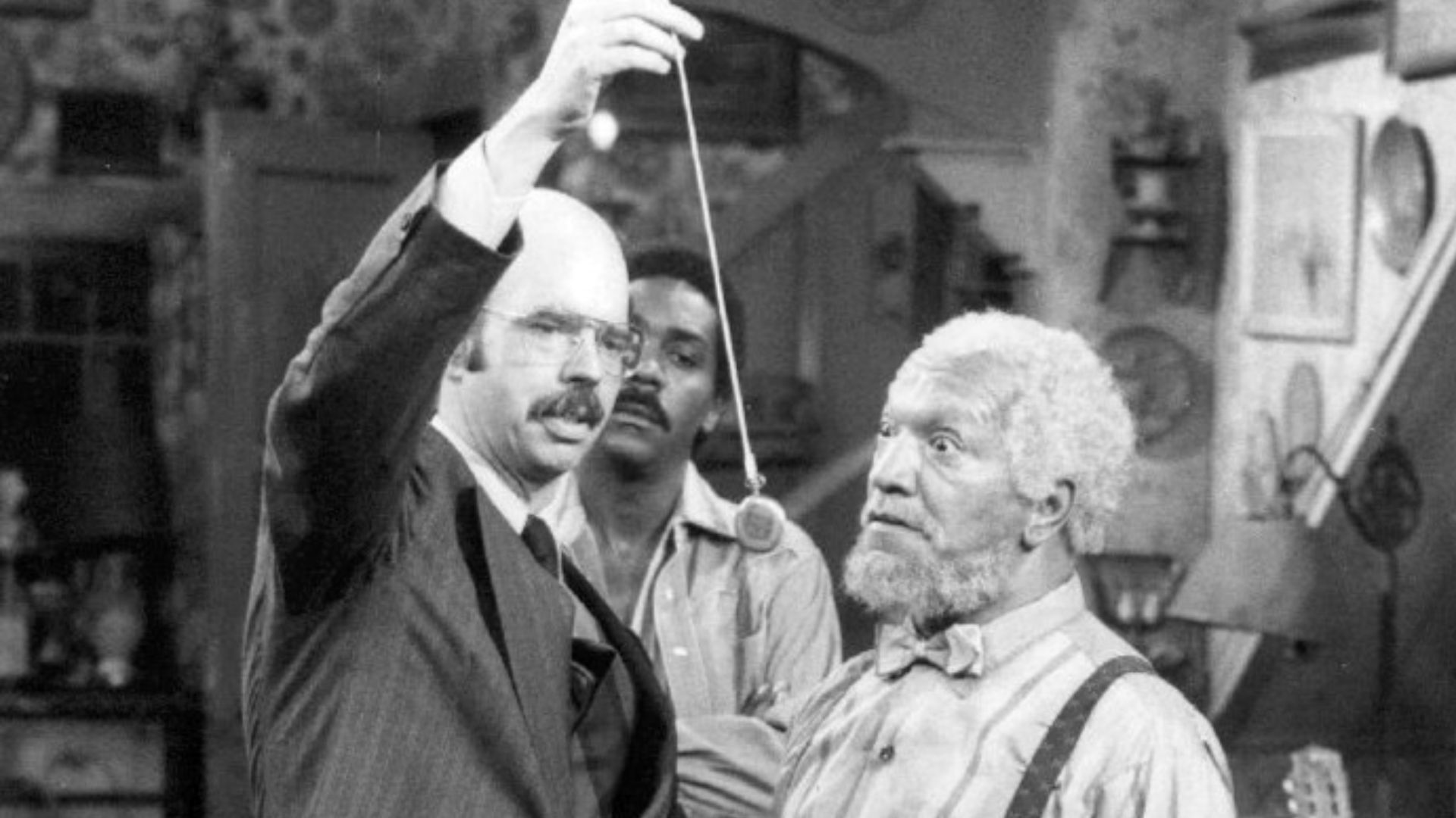 Photo of Redd Foxx, Graham Jarvis and Demond Wilson from the television program Sanford and Son. Lamont watches as Fred tries hypnotism for his television addiction. (Note that, in this television broadcast, and deliberately intended to prevent viewer rep