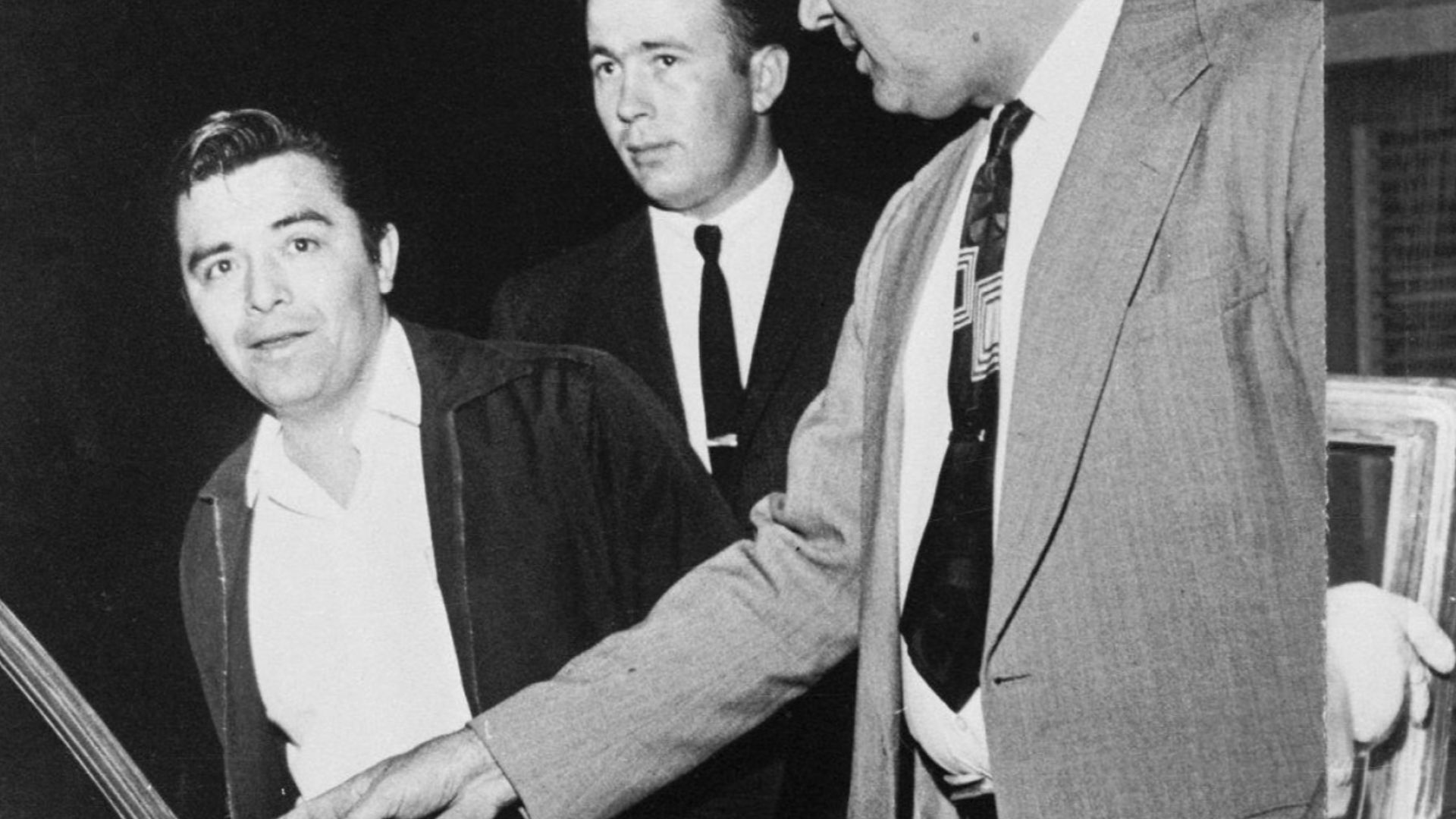 (Original Caption) Perry Smith (left in left photo) gets into a sheriff's car as undersheriff Wendel Meier (R) and Deputy Sheriff Mickey Hawkins look on. In picture at right, Richard Hickock starts into another car escorted by Sheriff Earl Robinson. Hicko