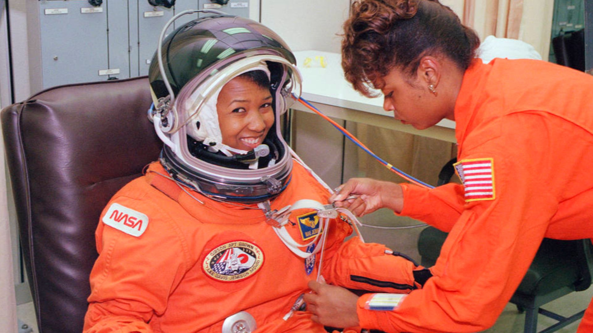 On Sept. 12, 1992, launch day of the STS-47 Spacelab-J mission on space shuttle Endeavour, NASA astronaut Mae Jemison waits as her suit technician, Sharon McDougle, performs a unpressurized and pressurized leak check on her spacesuit at the Operations and
