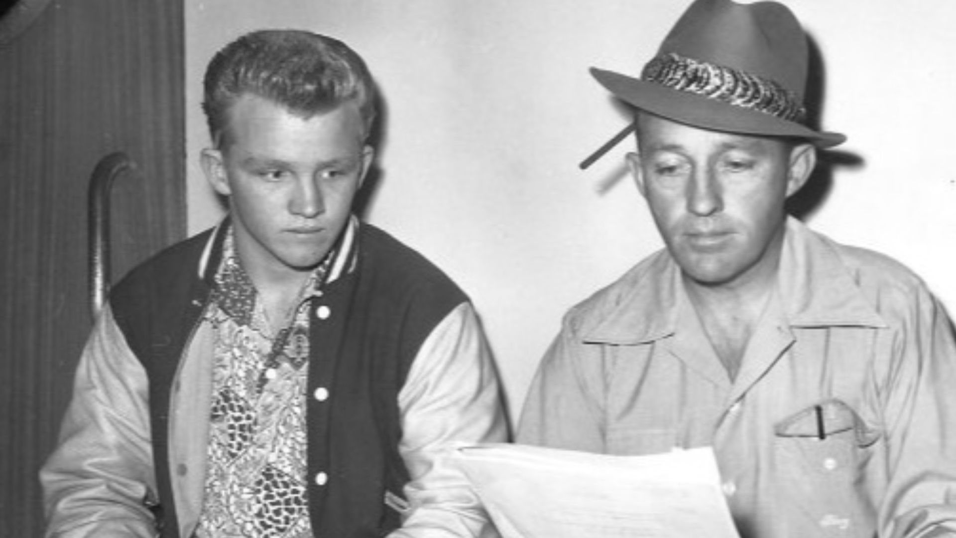 Publicity photo of Bing Crosby and his oldest son, Gary, reading a script from Bing's radio program.