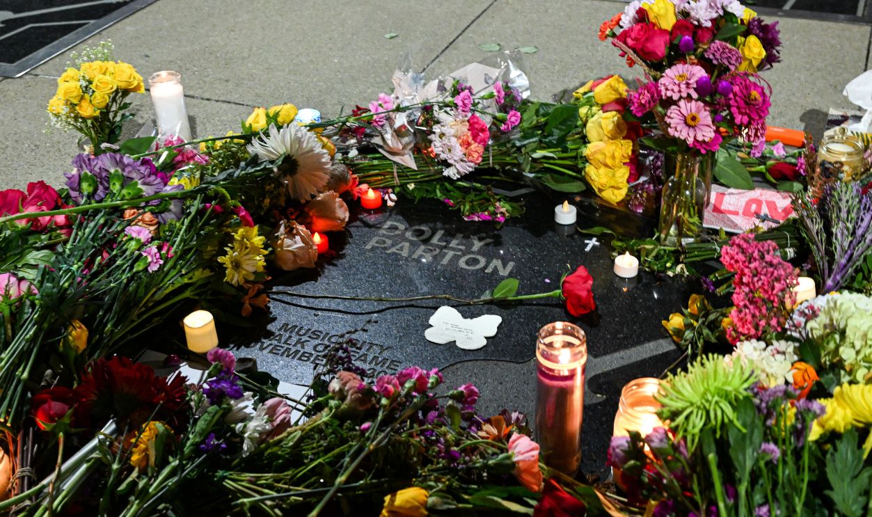 Getty Images - 2291537366 - Flowers and candles, placed by fans, cover the late US singer-songwriter Dolly Parton's star on The Music City Walk of Fame in Nashville, Tennessee on August 25, 2026. Dolly Parton, the American country music singer who rose from poverty in Tennessee to become a US cultural giant with hits like Jolene and 9 to 5, has died at 80, her family said on August 25.