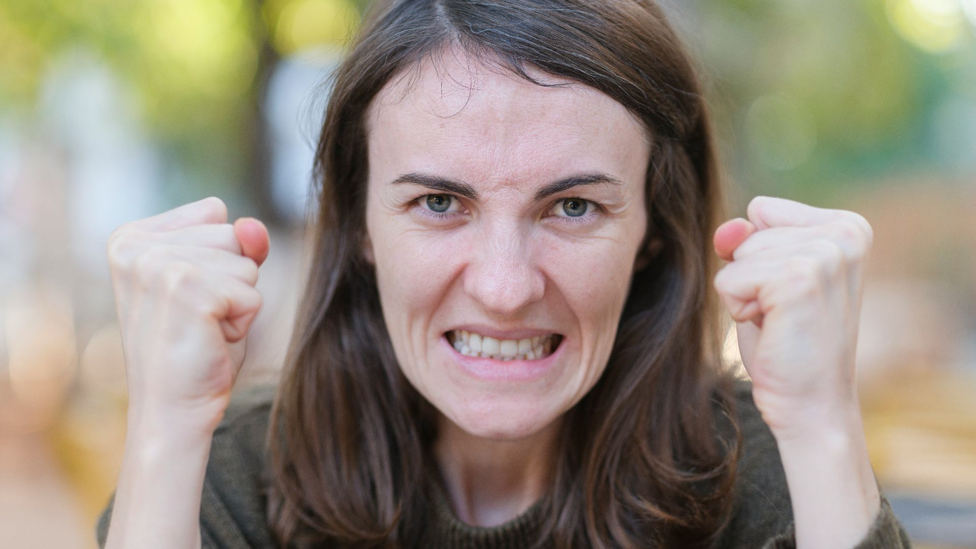 a woman holding her fists up in the air